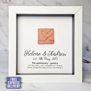 May include: A white framed print with a terracotta heart and the text "Helena & Andrew est. 18th May, 2015 9th anniversary - pottery Just like pottery, love is moulded into a thing of beauty through the hands of those who cherish it."