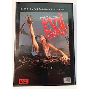 May include: A DVD case for Sam Raimi's The Evil Dead Special Collector's Edition. The cover art features a person with one arm raised, emerging from dark, tangled brush against a twilight sky. The title is in large, bold red lettering.