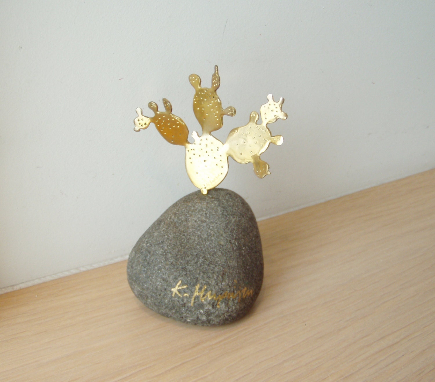 Brass cactus sculpture, opuntia cactus sculpture on grey stone, prickly