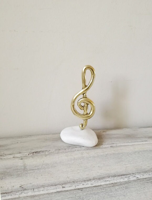 Treble clef sculpture, brass treble clef on white stone, treble clef