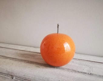 Ceramic orange sculpture, orange fruit in bright orange, earthenware clay orange with black, metal stem