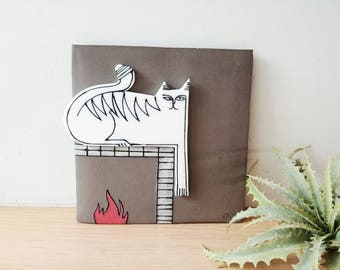 White cat wall hanging, porcelain cat in grey background, square wall tile of stoneware and porcelain, cat on the fireplace