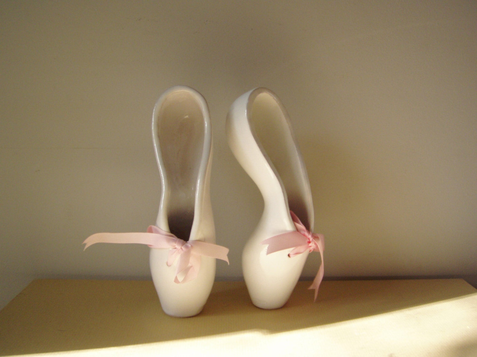 ballerina shoes sculpture, ceramic ballerina shoes of high fire, stoneware clay in milky white with satin, pink ribbons, ballet