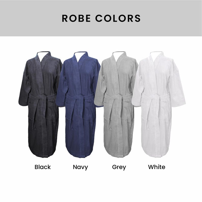 May include: Four bathrobes in different colors: black, navy, gray, and white. The robes are all made of a soft, plush material and have a classic design. "ROBE COLORS" is written in black text at the top of the image.