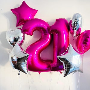 May include: A pink number 21 balloon bouquet with silver star and heart balloons.