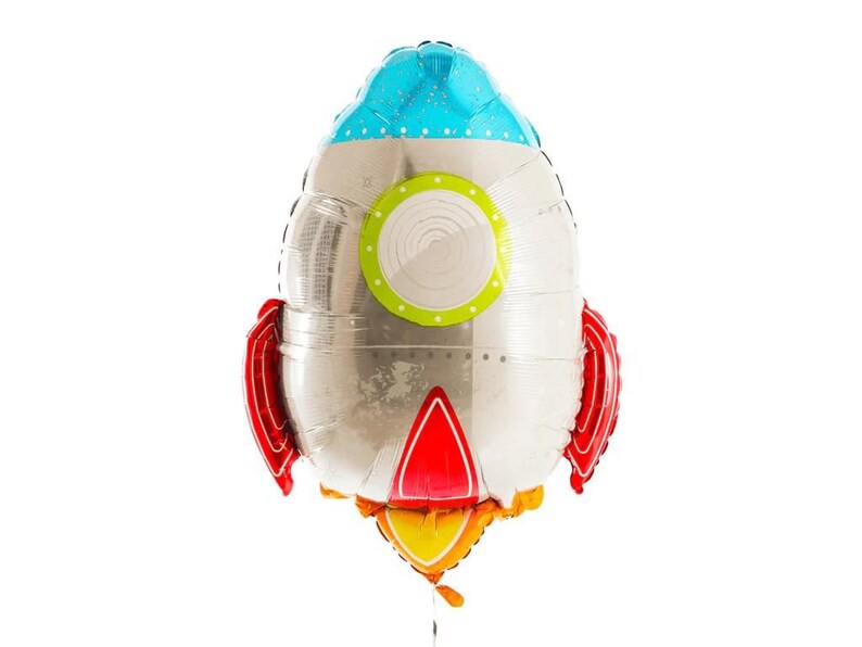 K&ouml;nnte beinhalten: Ein silberner Folienballon in Form einer Rakete mit roten Flossen, einem blauen Oberteil mit wei&szlig;en Punkten und einem gr&uuml;n-wei&szlig;en Bullauge. Der Raketen-Auspuff ist gelb und orange.