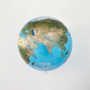 May include: A blue and green globe balloon with a map of the world printed on it. The balloon is tied to a string.