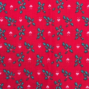 May include: Red fabric with a repeating pattern of teal holly leaves, white berries, and pink hearts. The design is evenly spaced across the fabric, creating a festive and seasonal look. Ideal for holiday-themed crafts and decor.