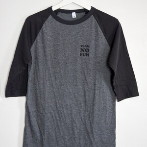 Raglan half length sleeve t-shirt in dark colours, screen printed to say Team No Fun in small type, in size medium.