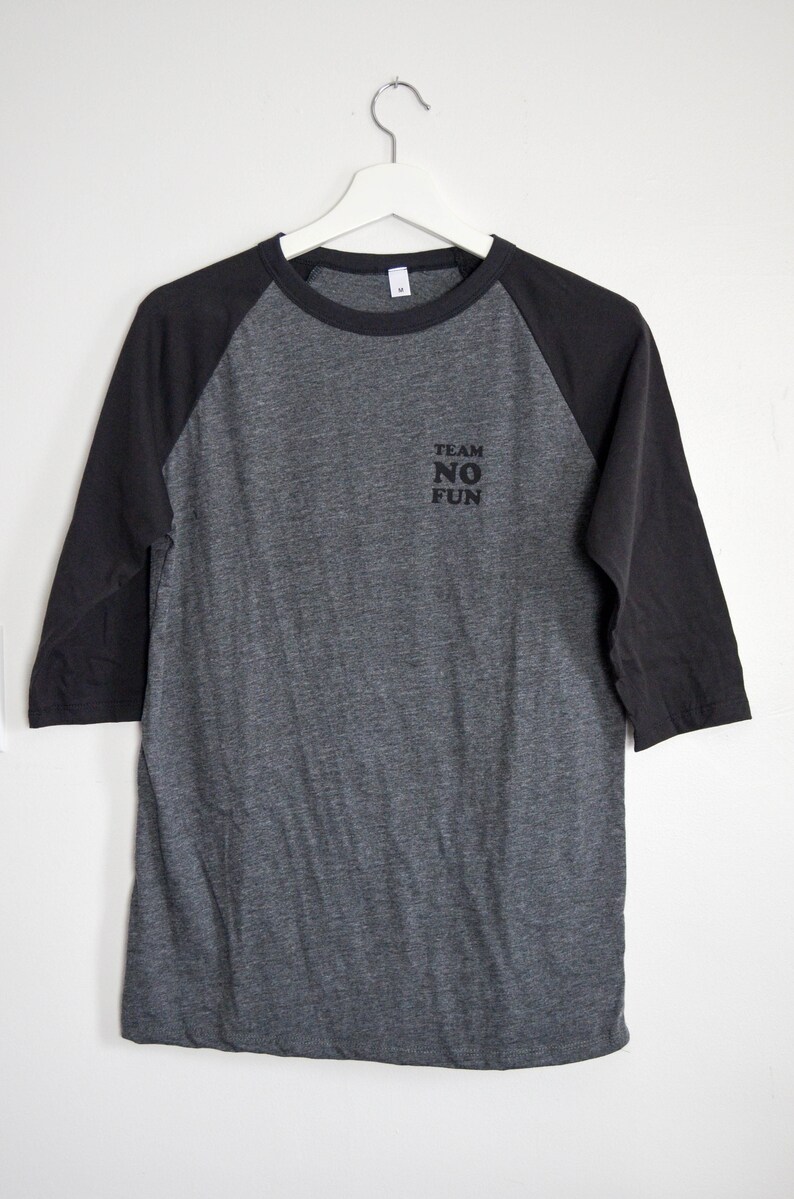 Raglan half length sleeve t-shirt in dark colours, screen printed to say Team No Fun in small type, in size medium.