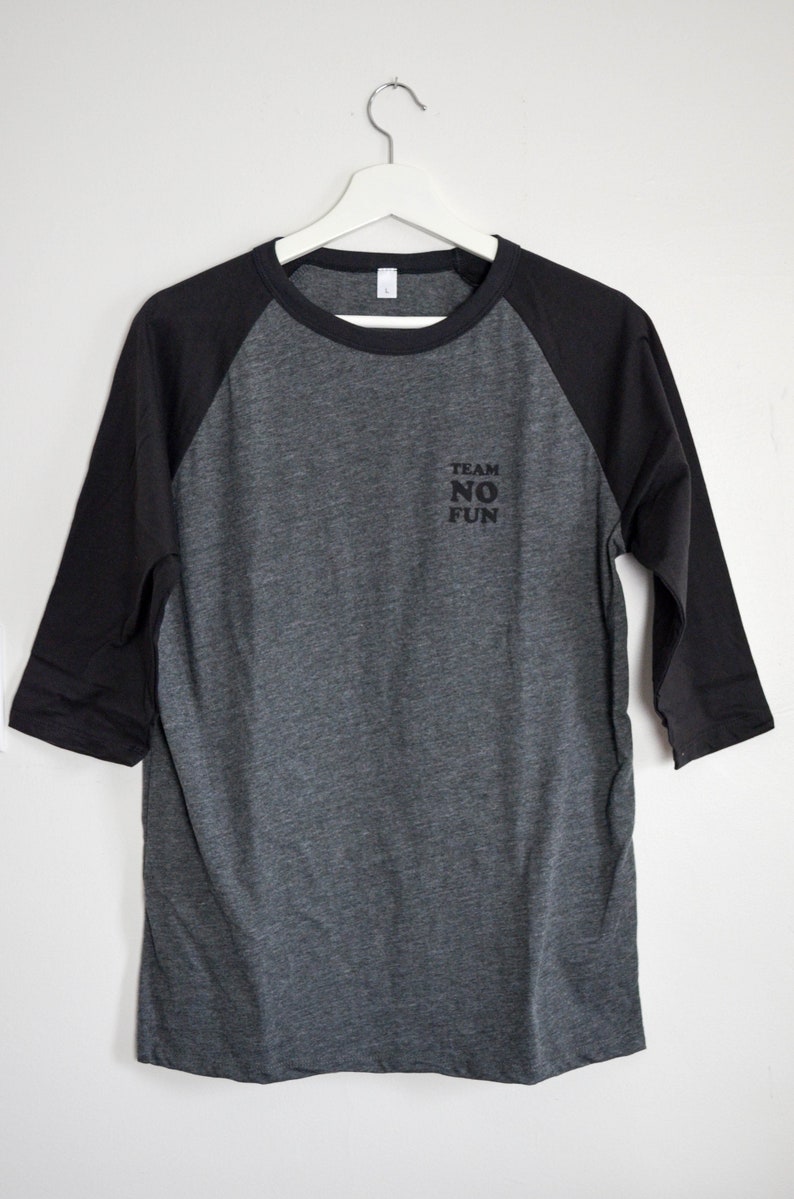 Raglan half length sleeve t-shirt in dark colours, screen printed to say Team No Fun in small type, in size large.