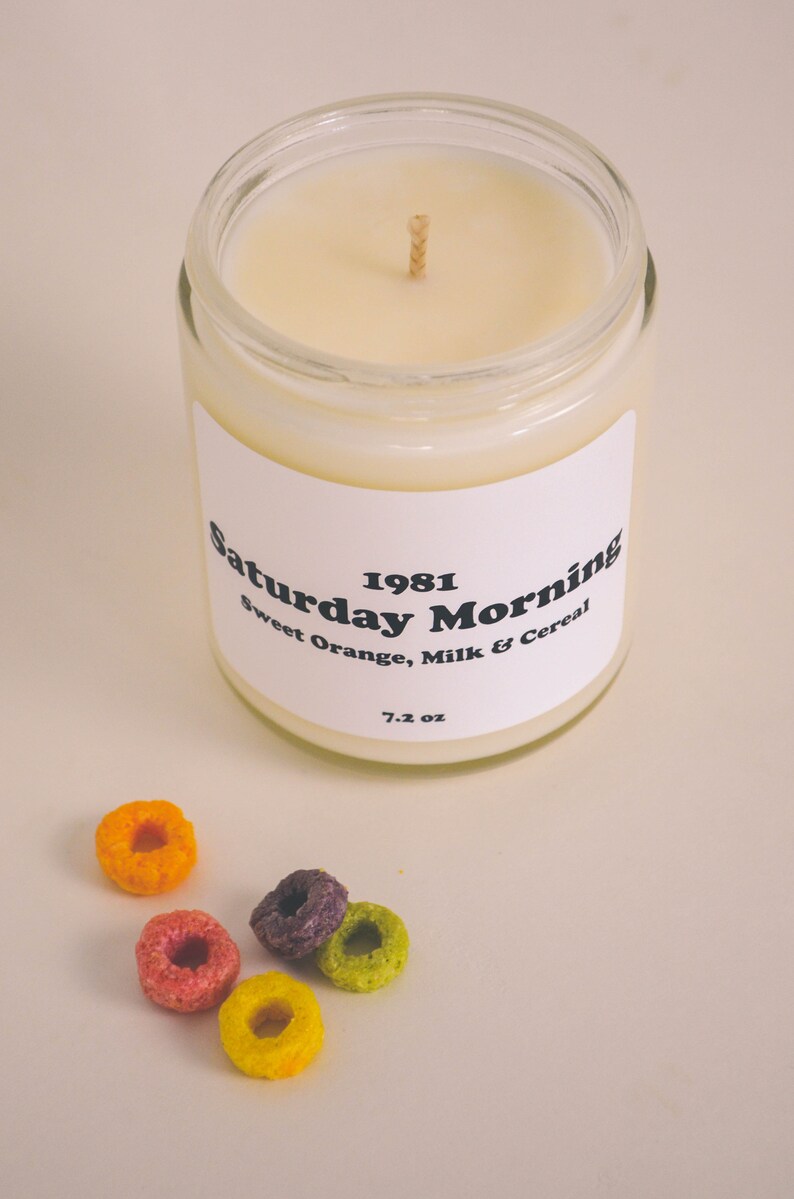 Large container candle in clear glass jar with metal lid, shown with Froot Loops cereal pieces.