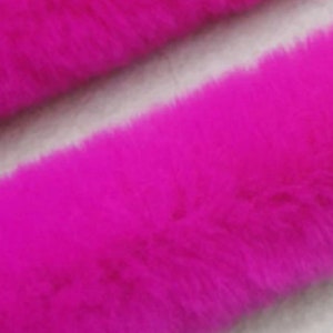 May include: A close-up of a bright pink faux fur fabric. The fabric has a soft, fluffy texture.