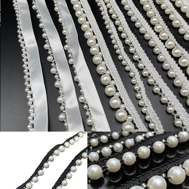 May include: An assortment of decorative trims featuring white faux pearls. The trims include white satin ribbon, white lace, and black and white woven trim, all adorned with various sizes of faux pearls. The trims are arranged on a black surface.