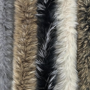 Peut inclure: Une collection de cinq longues bandes verticales de fausse fourrure disposées côte à côte. Les couleurs incluent le gris uni, le brun clair, le noir profond avec des reflets blancs, le blanc cassé et un mélange brun foncé et beige.