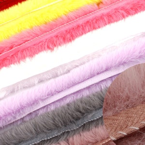May include: A close-up of a variety of faux fur trim in different colors, including red, yellow, pink, lavender, gray, and brown. The trim is soft and fluffy, and it would be perfect for adding a touch of luxury to any project.