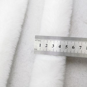 May include: White faux fur trim with a ruler measuring 9 centimetres in length.