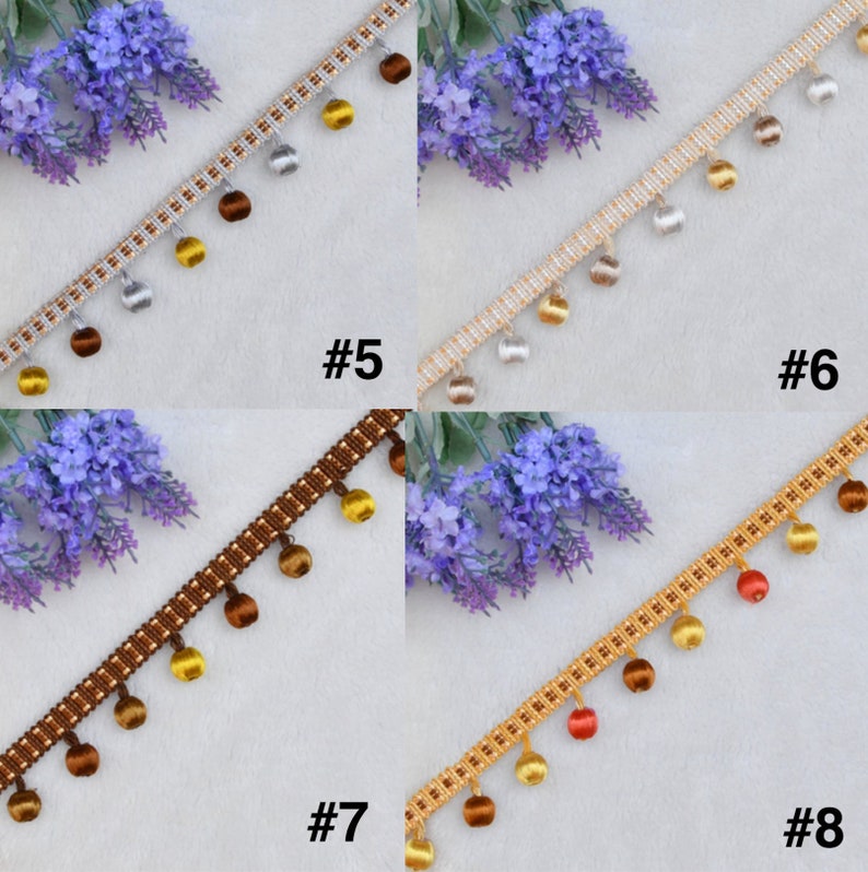 K&ouml;nnte beinhalten: Vier Muster von Besatz mit Quasten. Der Besatz ist ein gewebter Stoff mit einem sich wiederholenden Muster aus kleinen Quadraten. Die Quasten sind aus einem weichen, seidenartigen Material gefertigt und in verschiedenen Farben erh&auml;ltlich, darunter Gold, Silber, Braun und Rot. Der Besatz ist mit #5, #6, #7 und #8 gekennzeichnet.