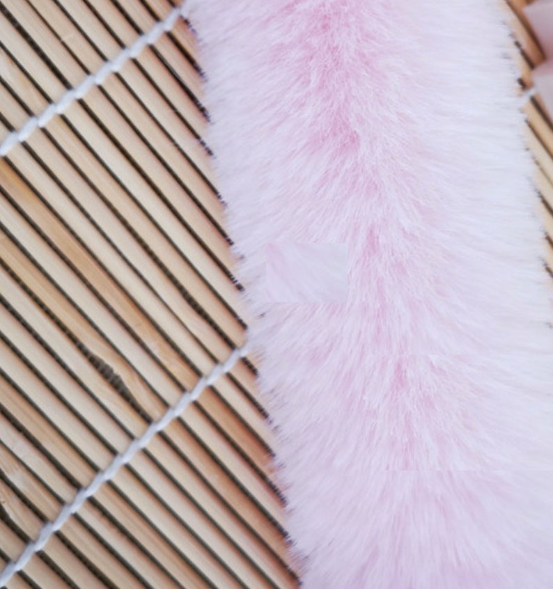 May include: A long, fluffy pink faux fur trim. The fur is soft and plush, and it would be perfect for adding a touch of luxury to any project.