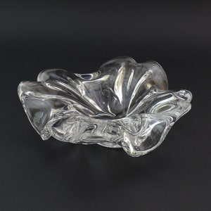 May include: A clear glass bowl with a wavy, organic shape. The bowl is designed with a series of folds and curves, creating a unique and modern aesthetic.