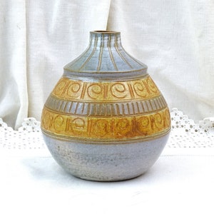 Könnte beinhalten: Eine Keramikvase mit hellblauer Glasur und einem braunen und gelben geometrischen Muster. Die Vase hat einen runden Körper und einen schmalen Hals.