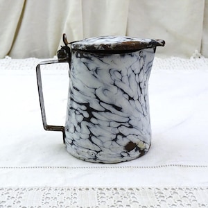 May include: A white and black marbled enamel pitcher with a hinged lid and a metal handle. The pitcher has a rustic, vintage look.