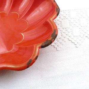 May include: A bright orange, scalloped serving dish with a gold trim. The dish is made of metal and has a vintage look.
