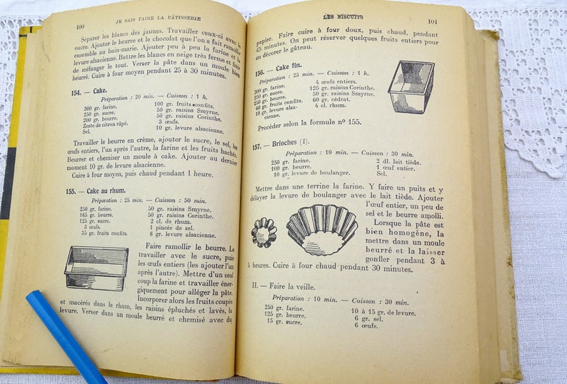 Pode incluir: Um antigo livro de culin&aacute;ria franc&ecirc;s com capa amarela e interior branco. O livro est&aacute; aberto em uma p&aacute;gina com uma receita de bolo. A receita inclui ingredientes como farinha, manteiga, ovos e passas. A p&aacute;gina tamb&eacute;m inclui uma ilustra&ccedil;&atilde;o em preto e branco de uma forma de bolo.