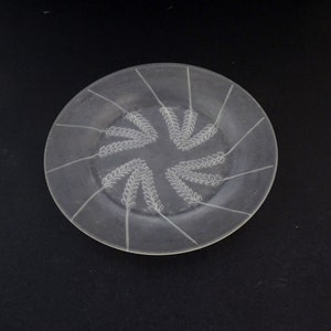 Könnte beinhalten: Ein klarer Glasteller mit einem in die Oberfläche geätzten Weizenmuster.