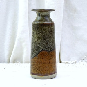 May include: A tall, ceramic vase with a narrow neck and flared rim. The vase features a two-tone design, with a dark green and brown upper section and a warm brown lower section. The vase is approximately 10 inches tall.