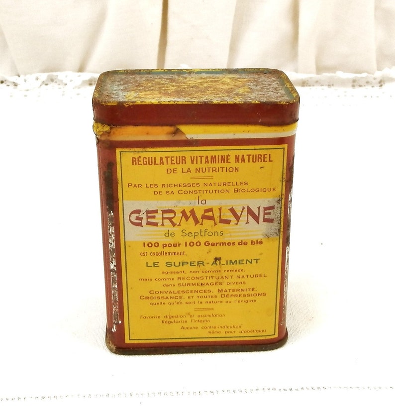 Puede incluir: Lata rectangular vintage con una etiqueta amarilla y roja. La etiqueta presenta texto en franc&eacute;s, incluyendo "GERMALYNE" y "R&Eacute;GULATEUR VITAMIN&Eacute; NATUREL." La lata tiene un aspecto ligeramente oxidado, lo que sugiere antig&uuml;edad. El producto es un regulador vitam&iacute;nico natural.