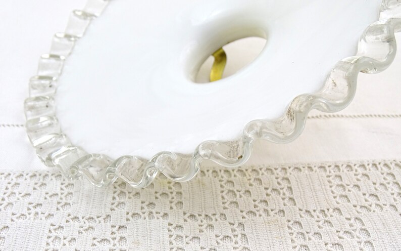 Puede incluir: Plato para pastel de vidrio blanco lechoso con borde festoneado. El plato tiene un agujero en el centro para un pedestal.