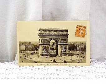 May include: Vintage postcard featuring a black and white photo of the Arc de Triomphe in Paris, France. The postcard has a stamp in the upper right corner.