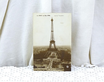 May include: Vintage postcard featuring a black and white photograph of the Eiffel Tower in Paris, France. The postcard has the text "no. PARIS - La Tour Eiffel vue du Trocadero" printed on it.