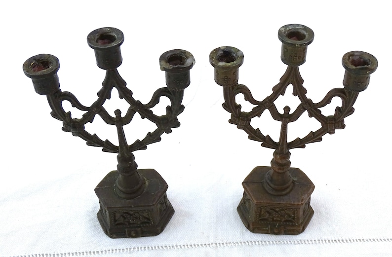 May include: Two antique bronze candelabra with ornate designs and five candle holders each.