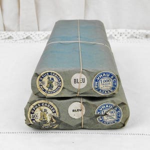 May include: Two bundles of blue thread wrapped in brown paper with labels that read "6 Fils Cables 70 Au Chinois" and "Ph. Vrau & Cie Lille 1000 Yards 914 Metres" and "Bleu".