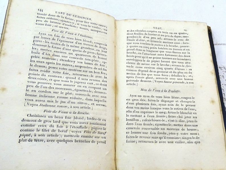 May include: A page from a vintage French cookbook, "L'Art du Cuisinier", with instructions on how to prepare veal dishes. The text describes different methods for cooking veal, including roasting, braising, and sauteing.