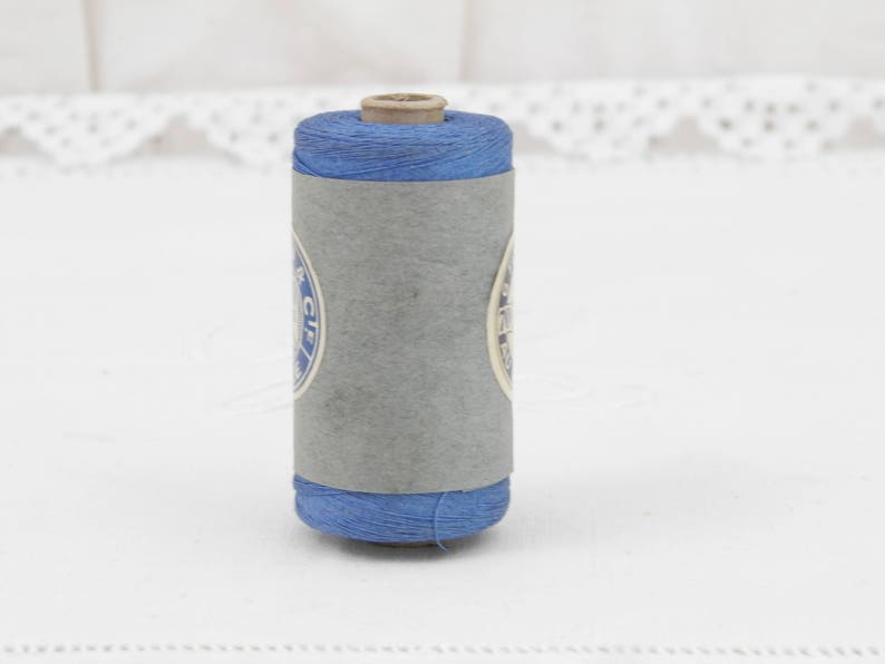 May include: A spool of blue thread with a white label that says "C.I.F."