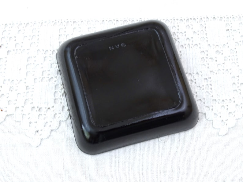 May include: Black square tray with a raised edge and the letters "RVS" stamped on the bottom.