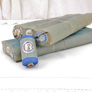 Könnte beinhalten: Eine Spule blauen Fadens, umwickelt mit Papier mit Etiketten, auf denen "Fils Carres Au Chinois" und "100 Yards 91.44 m" steht.