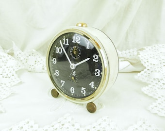 Reloj despertador mecánico de cuerda estilo francés de mediados de siglo, de los años 60, en funcionamiento, blanco con esfera negra, reloj retro, decoración para dormitorio.