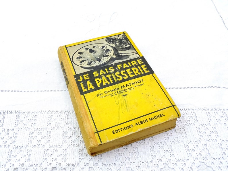 Pode incluir: Um livro de cozinha vintage amarelo intitulado "Je Sais Faire La Patisserie" de Ginette Mathiot, Inspecteur d'Etablissement M&eacute;nager de la Ville de Paris. O livro &eacute; publicado por Editions Albin Michel.