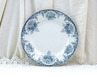 May include: A white ceramic plate with a blue floral design. The plate has a scalloped edge and a raised rim.