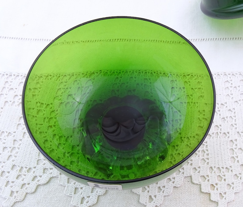 Puede incluir: Un cuenco de vidrio verde con un patr&oacute;n decorativo. El cuenco est&aacute; vac&iacute;o y tiene una superficie lisa y brillante.