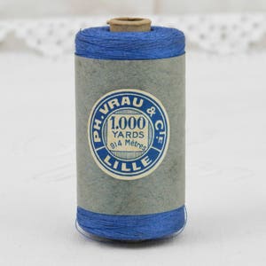 May include: A spool of blue thread with a label that reads "Ph. Vrau & Cie. 1,000 Yards 914 Metres Lille."