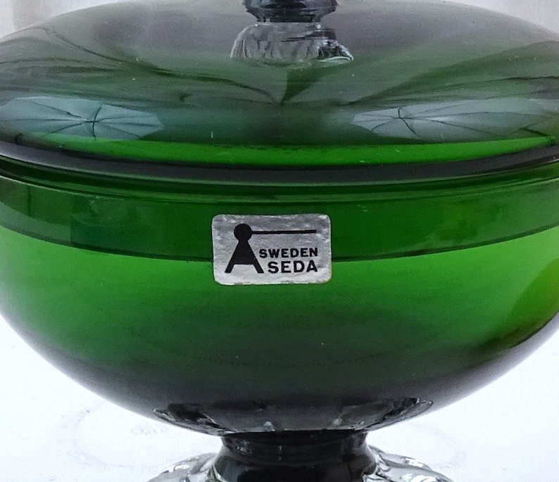 Puede incluir: Un taz&oacute;n de vidrio verde con tapa y una pegatina plateada que dice "Sweden Aseda".