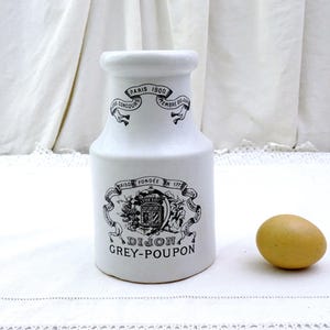 Könnte beinhalten: Weiße Keramik-Senfdose mit schwarzer Beschriftung "Maison Fondée en 1772 Dijon Grey-Poupon Paris 1900", einem schwarz-weißen Wappen und einem schwarzen Band mit den Worten "Grands Concours" und "Tembre D'Or".