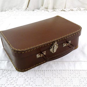 Pequeña maleta infantil vintage francesa de cartón marrón con asa de metal, años 60. Maleta infantil retro destartalada de Francia. Bolso de viaje antiguo.