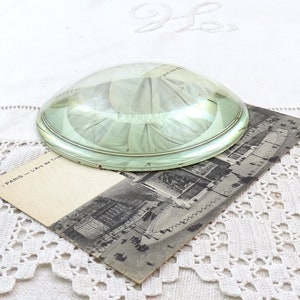 Puede incluir: Una lupa grande de vidrio transparente con un borde plateado. La lupa está sobre una postal vintage con el texto "37 - PARIS - L'Arc de Triomphe".