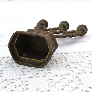 May include: A vintage brass candelabra with three candle holders. The candelabra has a decorative design and is in good condition.
